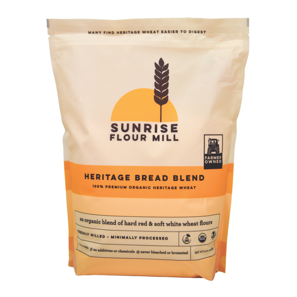 Bag of Sunrise Heritage Bread Flour with wheat logo and sun graphic on beige packaging (farmer-owned, organic heritage wheat)