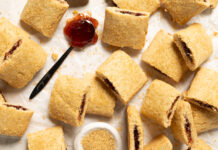 Soft Double-Berry Bars Assorted lemon bars with jam filling scattered on parchment paper.