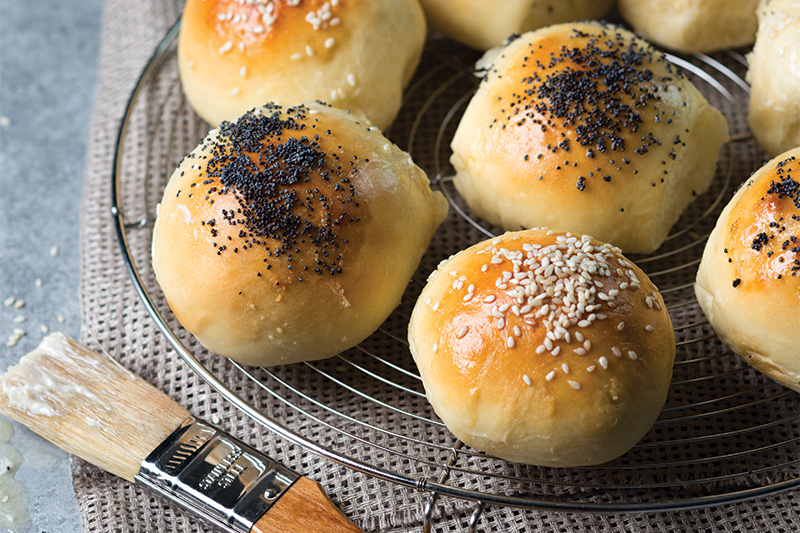 Bread Rolls with poppyseed and sea salt on wire rack