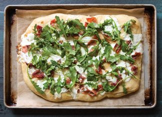 Focaccia with Burrata, Prosciutto, and Arugula Focaccia with Burrata, Prosciutto, and Arugula on sheet pan with parchment