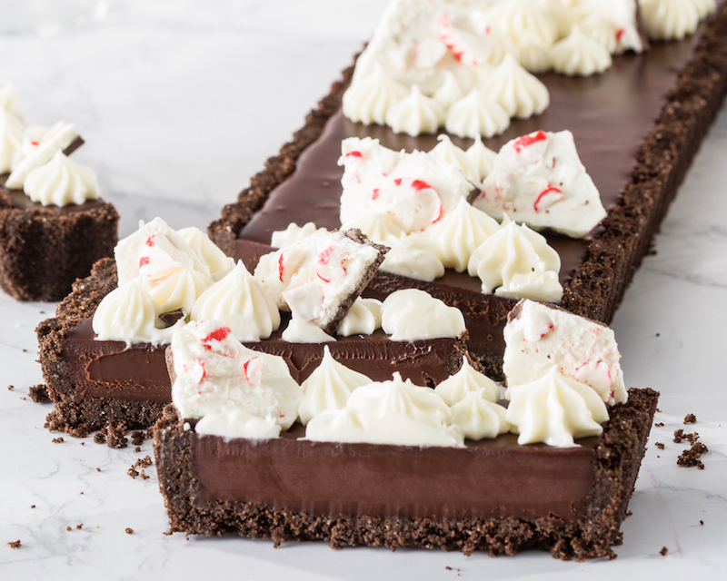 triple-chocolate peppermint tart sliced on white marble