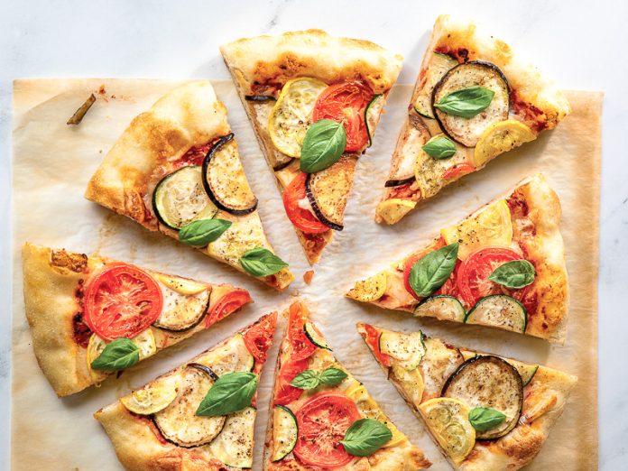 ratatouille pizza sliced on parchment paper