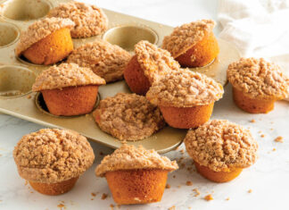 Pumpkin Snickerdoodle Muffins Snickerdoodle Pumpkin Muffins in GoldTouch muffin tin scattered on white surface.