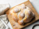 Baking School In-Depth: Pan de Muerto pan de muerto baking school in depth module. bread sugared on wooden cutting board