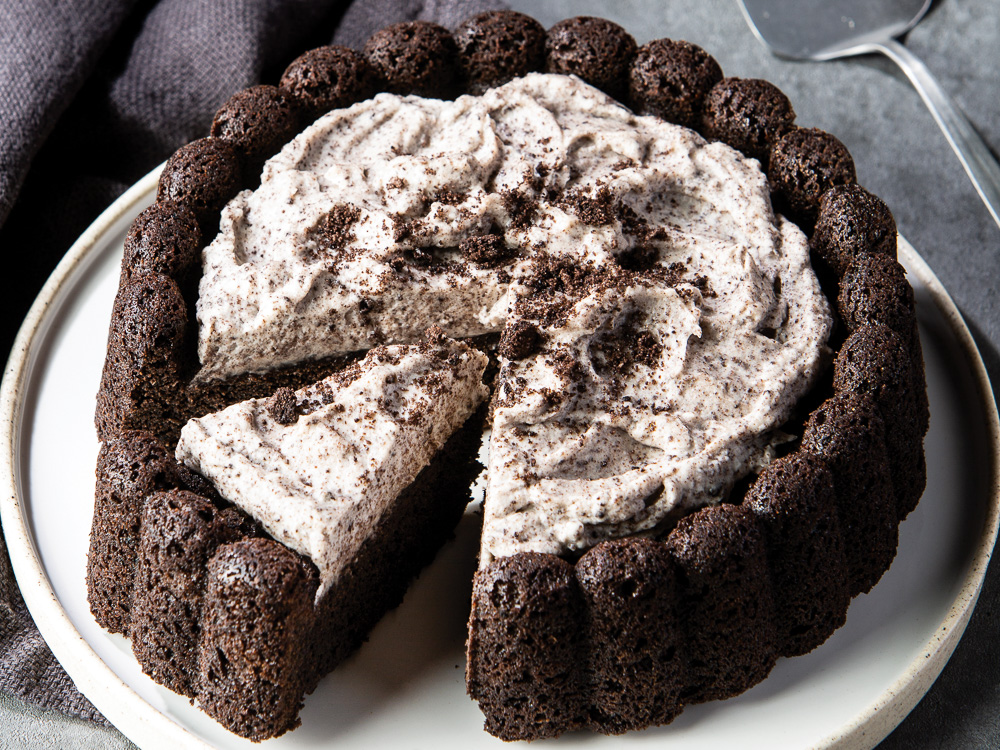 Black Cocoa Cookies and Cream Cake on white plate sliced.