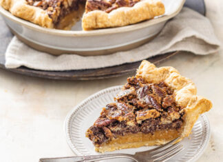 Deep-Dish Chocolate Chunk Pecan Pie Deep dish chocolate chunk pecan pie sliced on white plate with fork