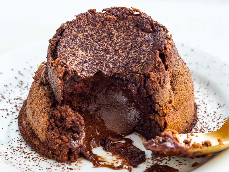 Dark Chocolate Lava Cake on White Plate with Gold Spoon