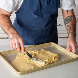 Spreading cake batter onto baking pan