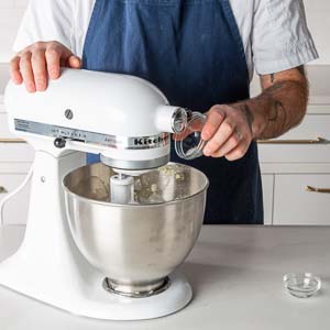 Adding almond extract to mixing bowl
