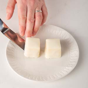 Putting petit fours on white plate
