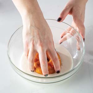 Dipping doughnut in glaze