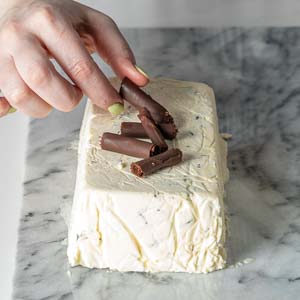 Placing chocolate curls on top of semifreddo