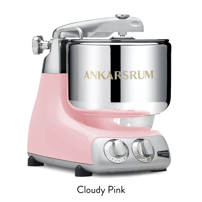 Pink retro-style stand mixer with a shiny chrome mixing bowl and vintage control dials on the front.] ,