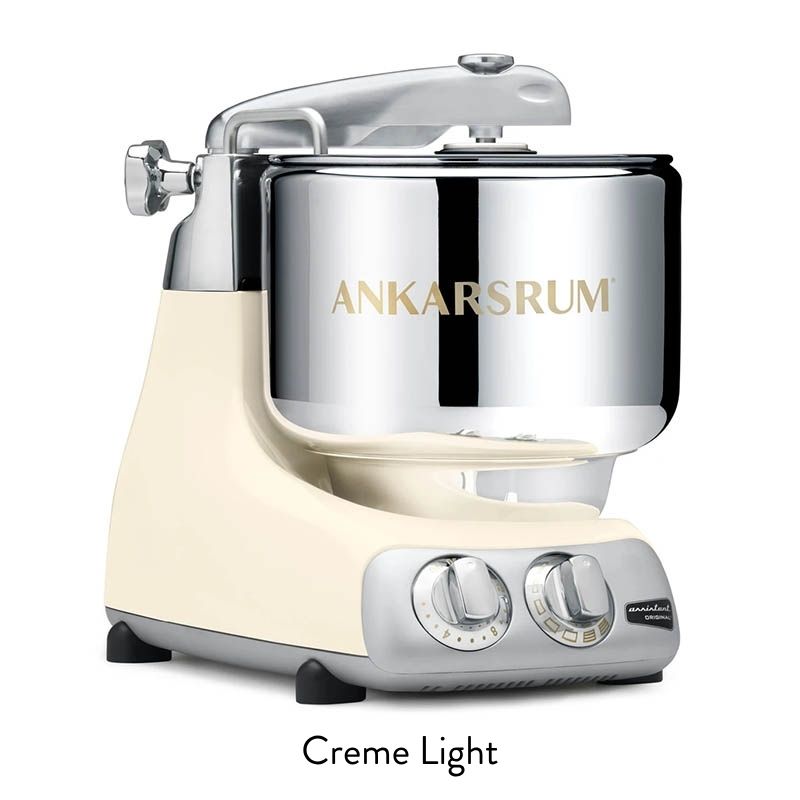 Ankarsrum Original Creme Light stand mixer with a chrome mixing bowl and front control dials.