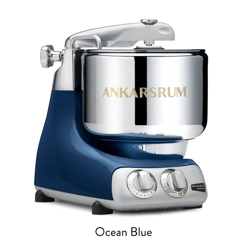 Ankarsrum ocean blue stand mixer with a shiny chrome bowl and control dials visible on the front edge.