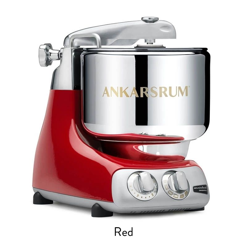 Red stand mixer with chrome mixing bowl and control dials on a white background