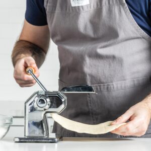 putting dough through pasta maker