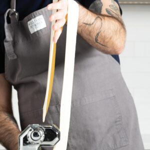 putting dough through pasta maker