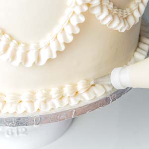 piping buttercream onto bottom of cake layer
