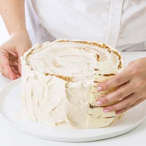 Putting chocolate bark on sides of cake