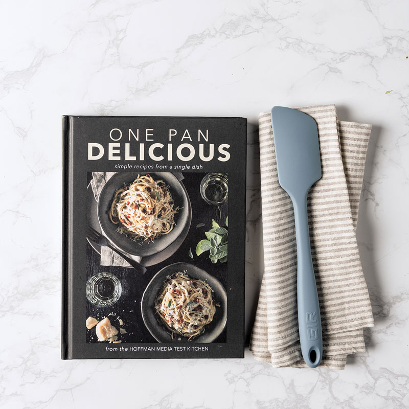 One Pan Delicious book, spatula, and linen towel