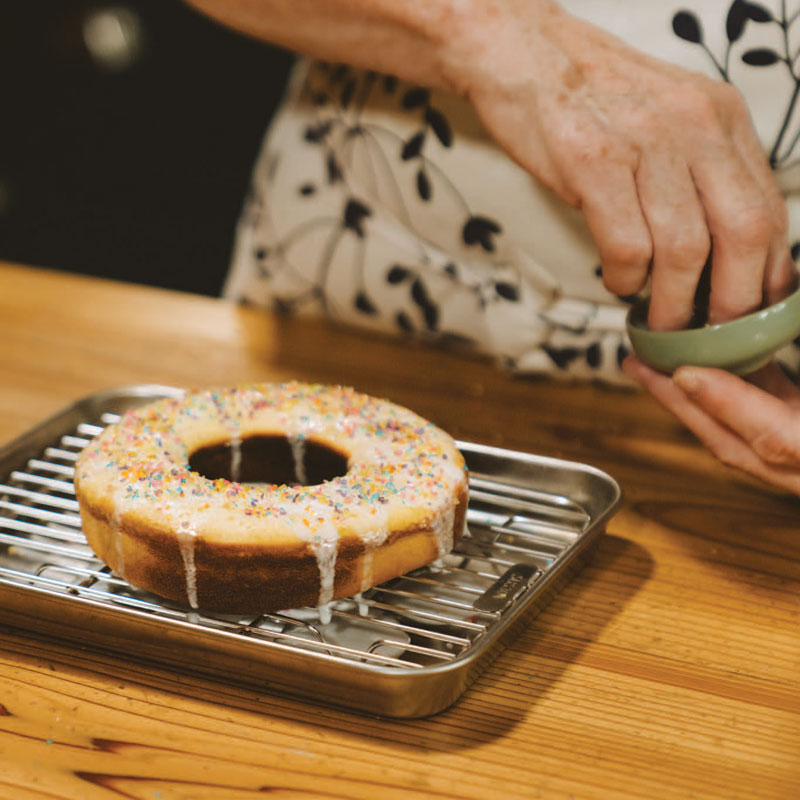 Sprinkling sprinkles on a cake