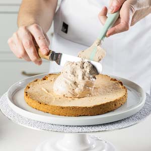 adding buttercream to cake layer