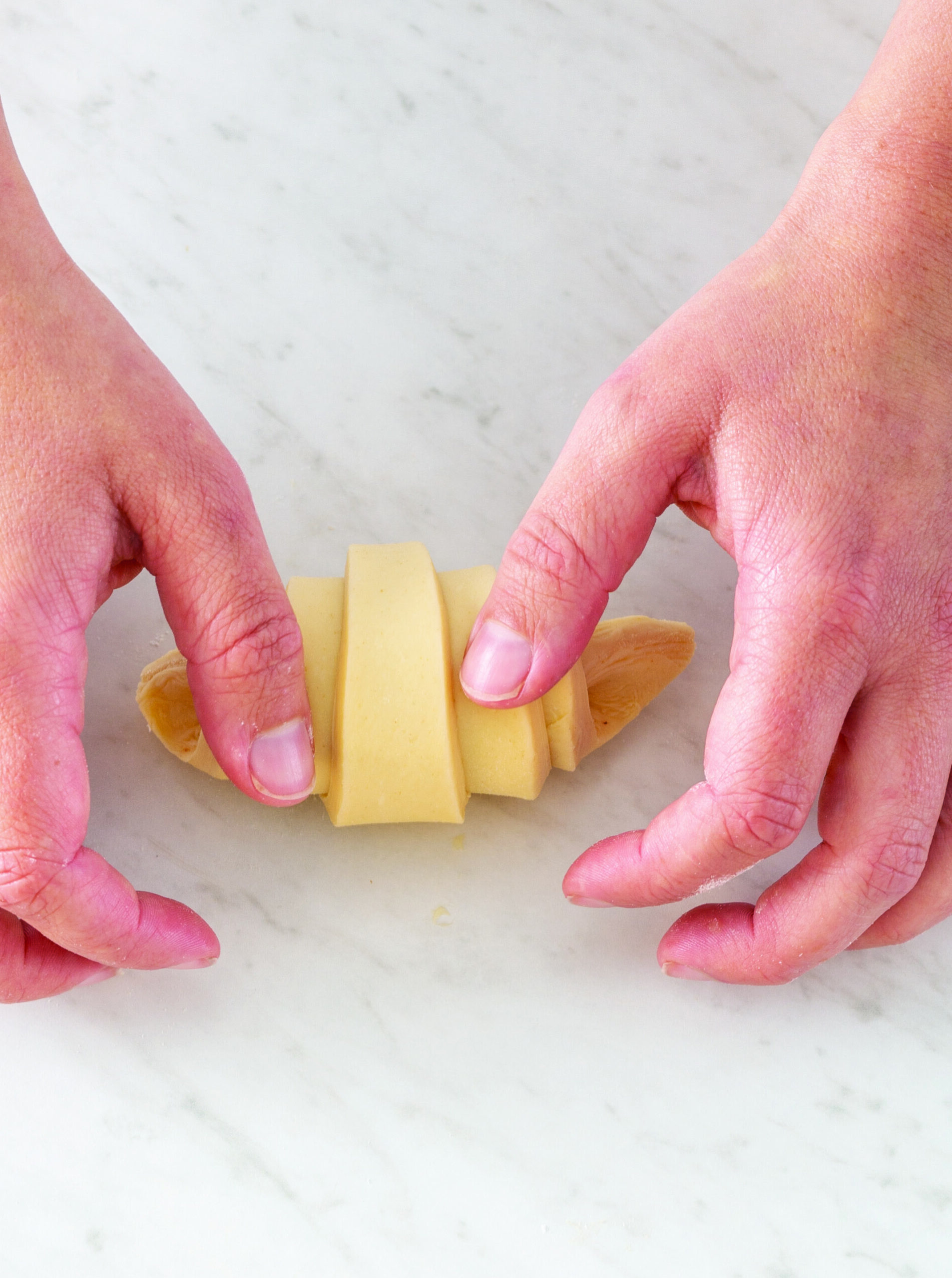 Hands shaping a croissant