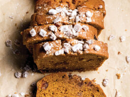 Pumpkin Date Loaf Sliced nutty loaf cake with walnuts and a light dusting of powdered sugar on parchment