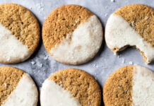 Salted Maple Espresso Cookies Row of round cookies with half white icing on a cool gray marble surface